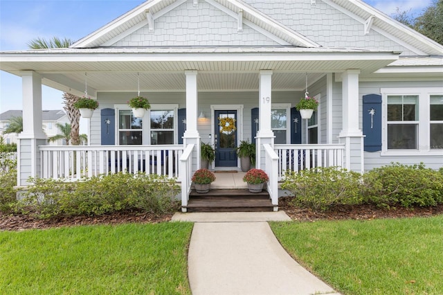 entrance to property featuring a yard and covered porch