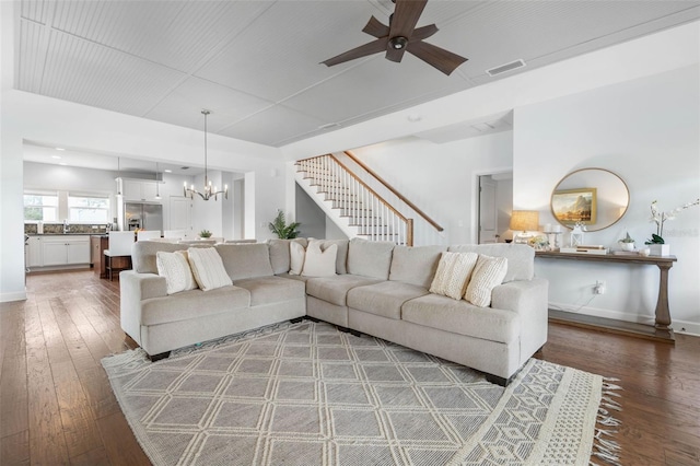 living room with ceiling fan with notable chandelier, hardwood / wood-style flooring, and sink