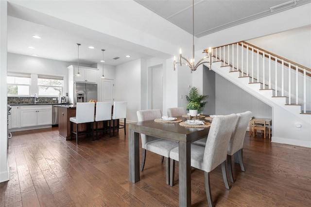 dining space featuring dark hardwood / wood-style floors, an inviting chandelier, and sink