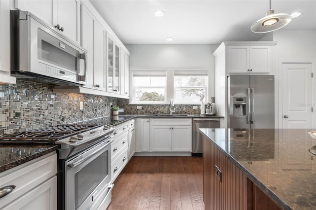 kitchen featuring pendant lighting, stainless steel appliances, dark hardwood / wood-style flooring, and white cabinetry