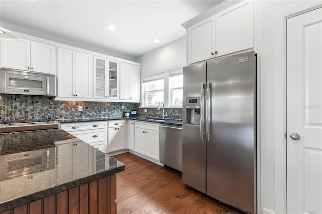 kitchen with dark stone counters, dark hardwood / wood-style floors, white cabinetry, and stainless steel appliances