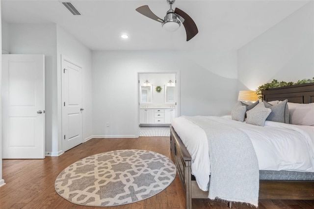 bedroom with ceiling fan, dark wood-type flooring, and connected bathroom