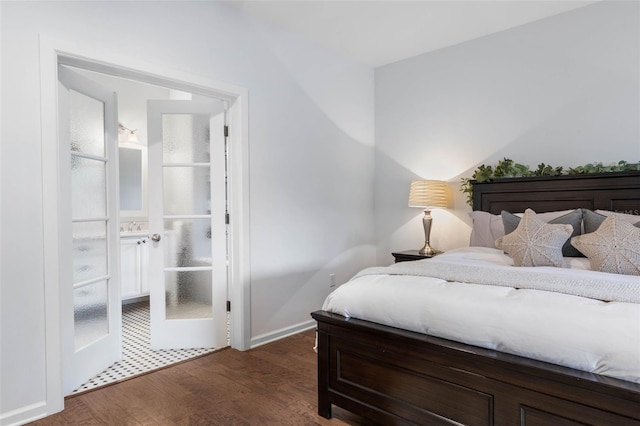 bedroom with connected bathroom and dark hardwood / wood-style floors