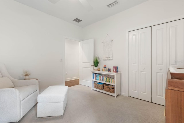 sitting room featuring ceiling fan and light colored carpet