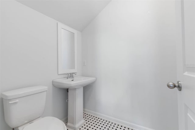 bathroom with vaulted ceiling, sink, and toilet