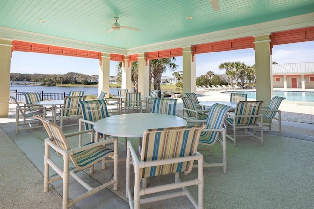 view of patio with a community pool, a water view, and ceiling fan