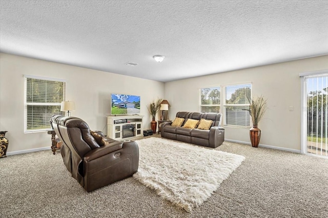 living room with a fireplace, a textured ceiling, and light carpet