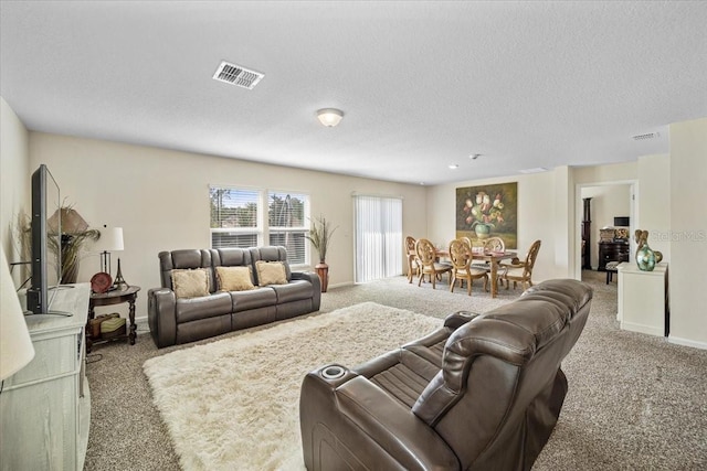 carpeted living room featuring a textured ceiling