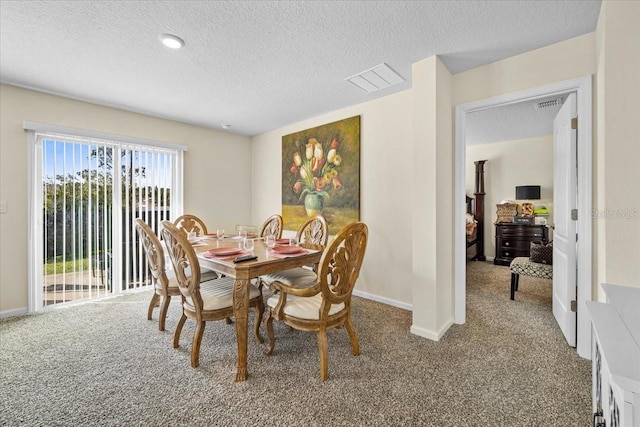 dining area with a textured ceiling and carpet flooring