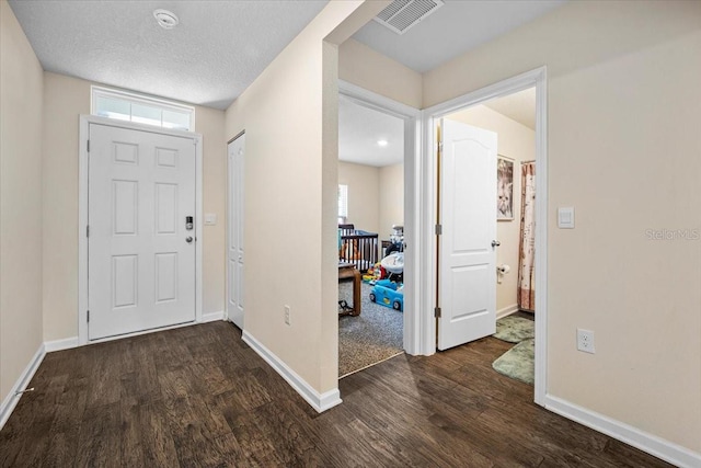 foyer with dark hardwood / wood-style floors and a textured ceiling