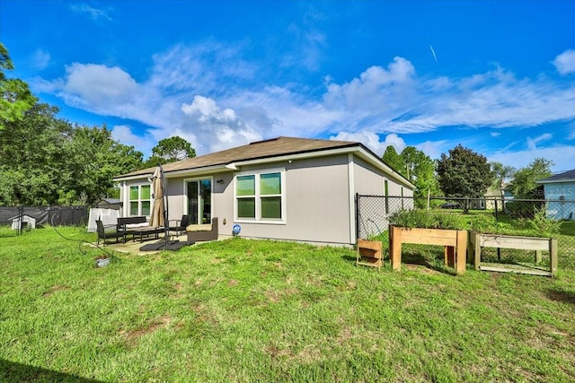 rear view of house featuring a lawn and a patio