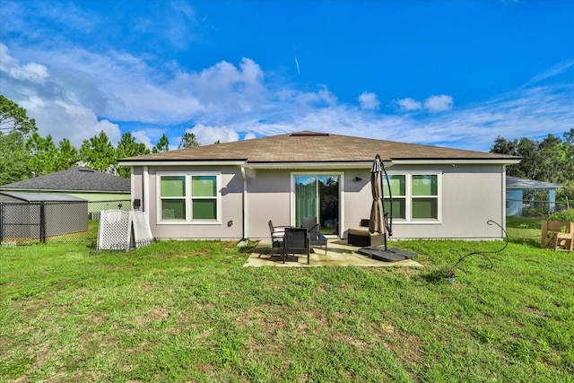 back of property with a yard and a patio area