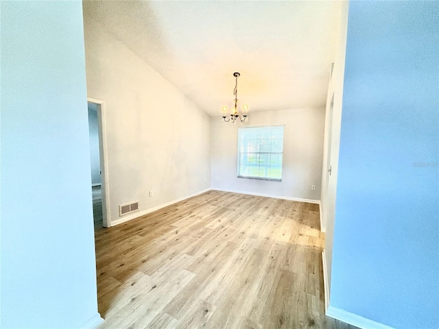 unfurnished room with light hardwood / wood-style floors and a chandelier