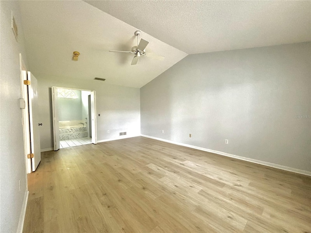 interior space featuring vaulted ceiling, a textured ceiling, light hardwood / wood-style flooring, and ceiling fan