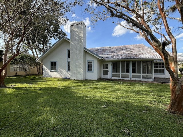 back of property featuring a yard and a sunroom