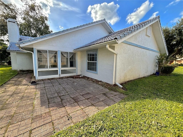 back of house with a patio area and a lawn