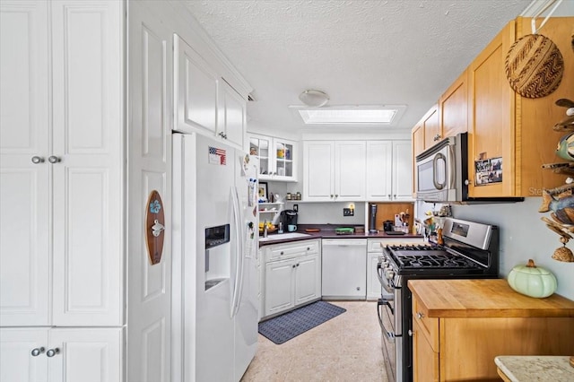 kitchen featuring appliances with stainless steel finishes, white cabinetry, and a textured ceiling