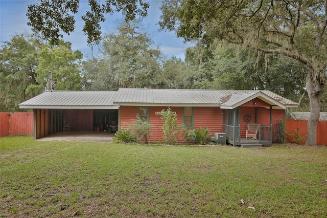 view of front of home featuring cooling unit, a front lawn, and a carport