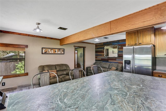 kitchen with beamed ceiling and stainless steel refrigerator with ice dispenser