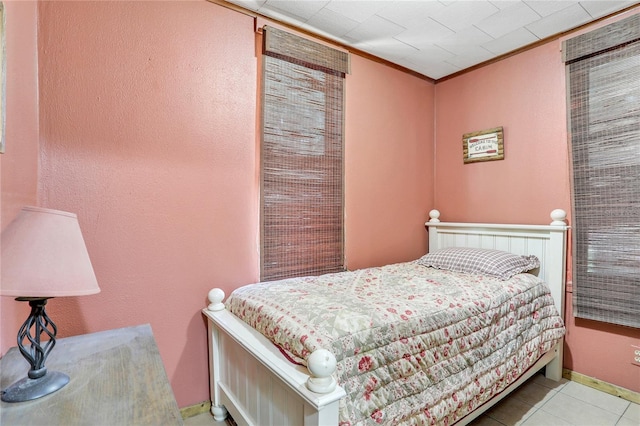 bedroom with crown molding and light tile patterned flooring