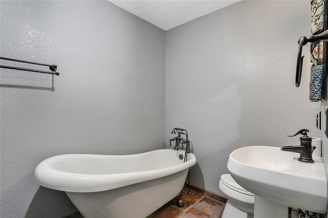 bathroom with toilet, sink, and a tub