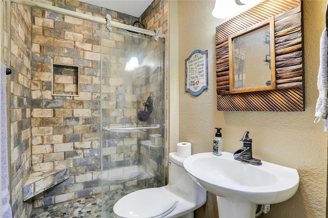 bathroom featuring sink, an enclosed shower, and toilet