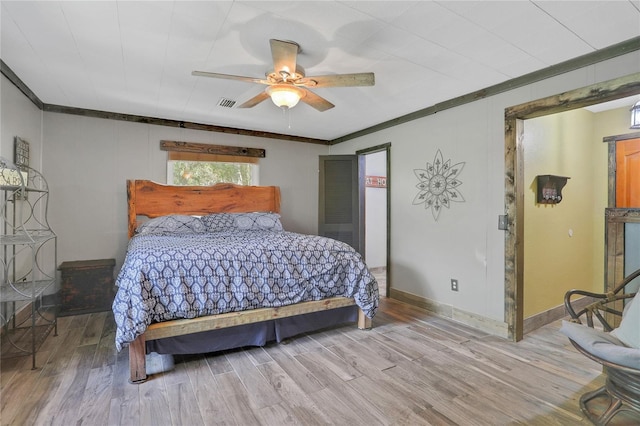 bedroom featuring hardwood / wood-style flooring, ceiling fan, and ornamental molding