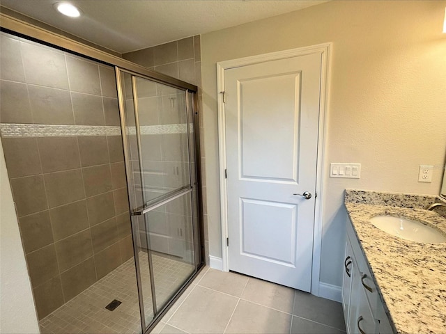 bathroom featuring tile patterned flooring, vanity, and an enclosed shower