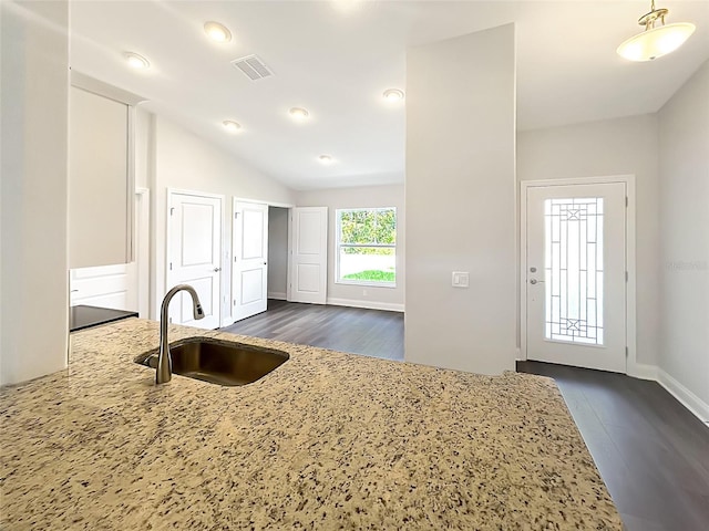 kitchen featuring dark hardwood / wood-style flooring, light stone countertops, sink, and vaulted ceiling