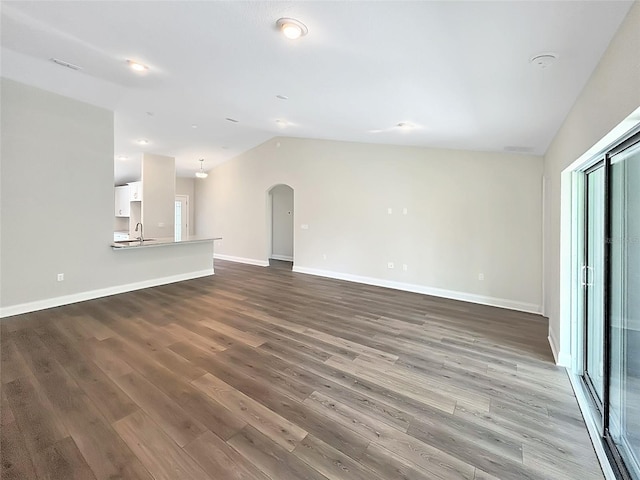 unfurnished living room with hardwood / wood-style floors, lofted ceiling, and sink