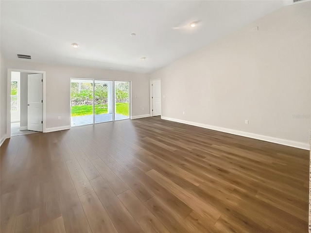 unfurnished room with dark wood-type flooring and vaulted ceiling