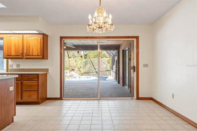 interior space featuring light tile patterned flooring, a textured ceiling, and a chandelier