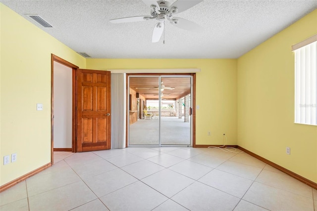 spare room with ceiling fan, light tile patterned flooring, and a textured ceiling