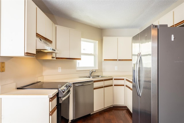 kitchen with dark wood-type flooring, sink, stainless steel appliances, white cabinets, and a textured ceiling