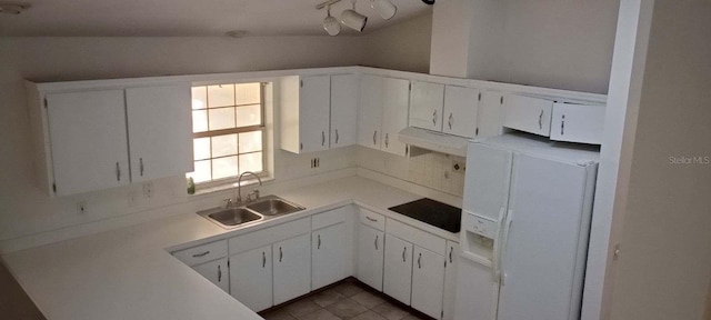 kitchen with white fridge with ice dispenser, light countertops, a sink, and white cabinetry