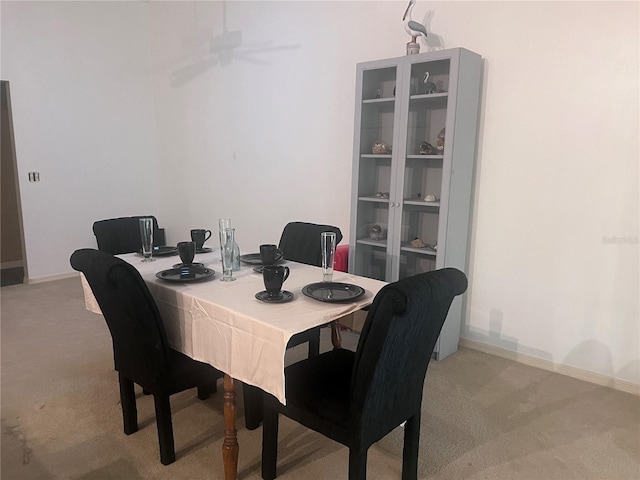 dining area featuring light carpet and baseboards