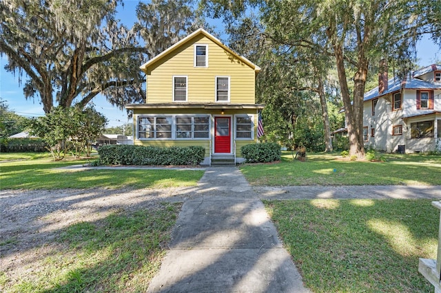 view of front of home with a front lawn and a sunroom