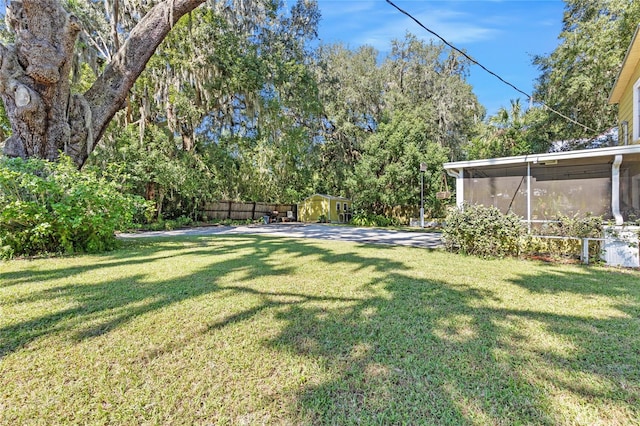 view of yard with a storage unit and a sunroom