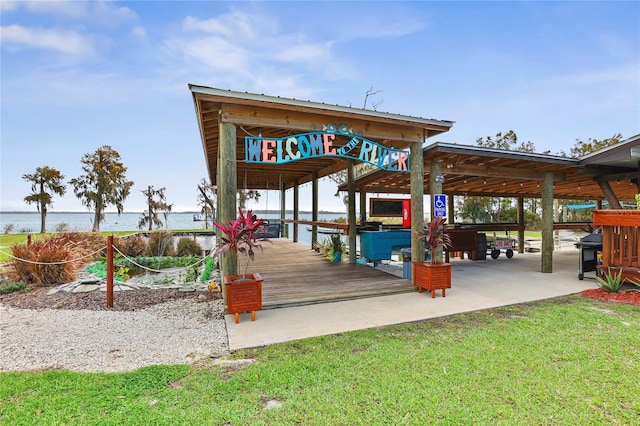 view of property's community with a water view and a lawn