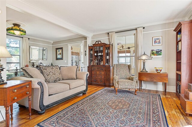 living room featuring crown molding, hardwood / wood-style flooring, and beam ceiling