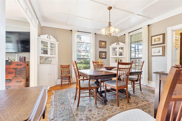 dining room featuring crown molding, light hardwood / wood-style flooring, and an inviting chandelier