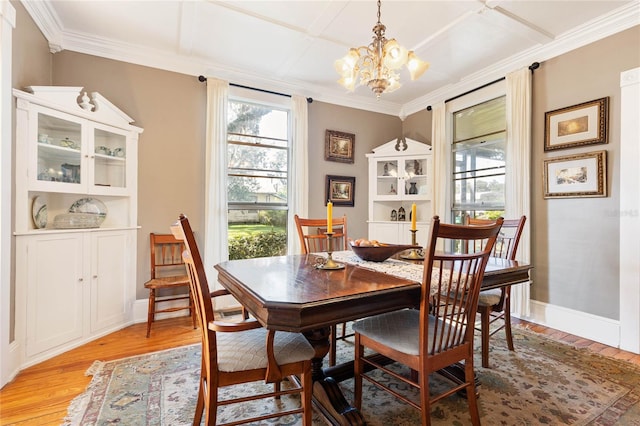 dining space featuring crown molding, coffered ceiling, a chandelier, and light wood-type flooring