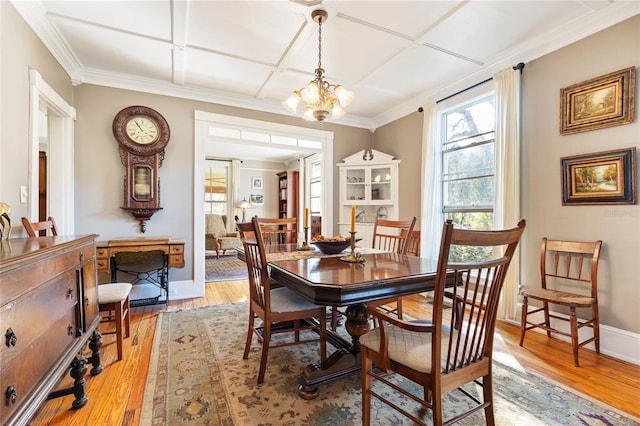 dining room with ornamental molding, light hardwood / wood-style flooring, and a notable chandelier