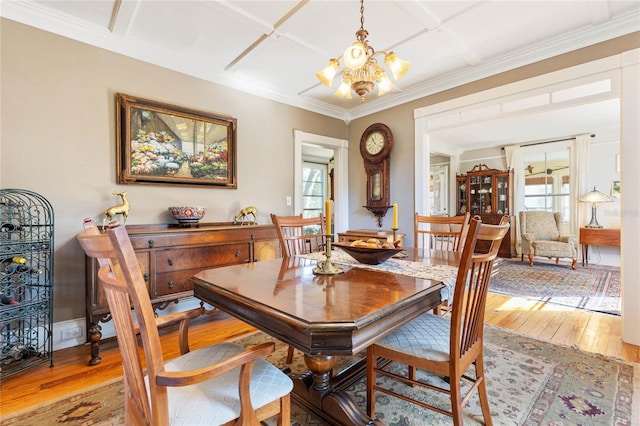 dining room featuring coffered ceiling, wood-type flooring, a chandelier, and plenty of natural light