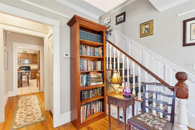 stairway featuring crown molding and hardwood / wood-style flooring