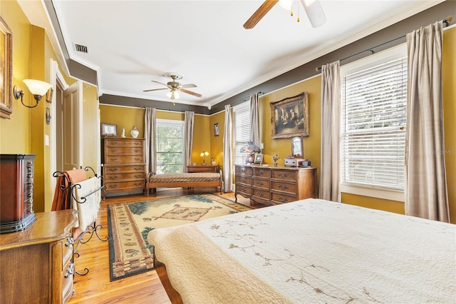 bedroom featuring crown molding, light hardwood / wood-style flooring, and ceiling fan