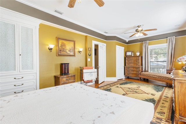 bedroom featuring ceiling fan, ornamental molding, and hardwood / wood-style floors