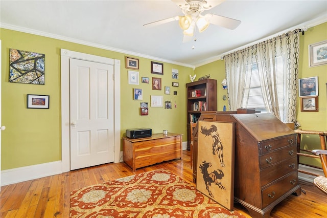 interior space with ceiling fan, ornamental molding, and light wood-type flooring