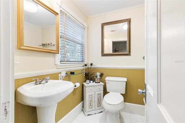 bathroom with tile patterned floors, crown molding, toilet, and wooden walls