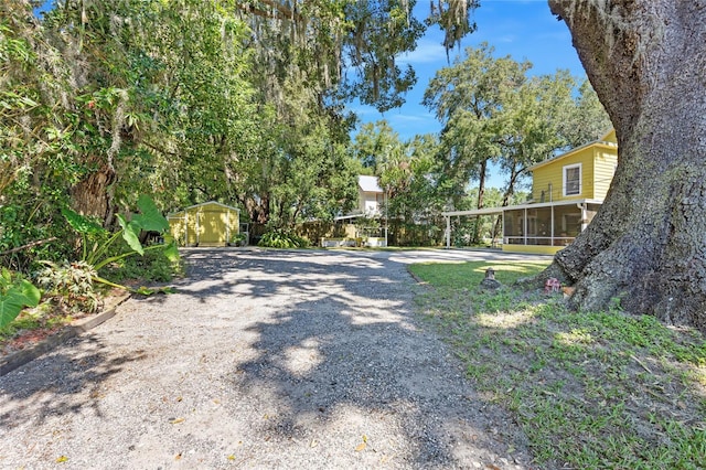 view of yard with a sunroom and a storage shed